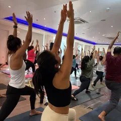 The energy of a full room moving together in Virabhadrasana I (Warrior I). This image captures the collective power and spirit of our community.