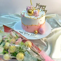 This elegant birthday surprise features a pastel pink and white cake with delicate edible butterflies. It was delivered at midnight along with a beautiful matching chocolate and flower bouquet.