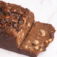 A slice of our decadent chocolate banana travel cake. It's incredibly moist and packed with chocolate chunks, making it a truly comforting treat.