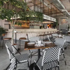 We ensured the furniture was versatile and easy to move, allowing the space to transform for different events and crowds. The black and white patterned chairs add a graphic pop to the industrial setting.