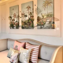 A duplicate of image 32, this photo emphasizes how the nature-inspired art panels and the mix of patterned and textured cushions work together. The entire composition is designed to make the space feel soft, inviting, and full of charm.