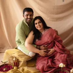 A joyful couple's portrait in traditional Indian attire. The vibrant colors and festive props create a celebratory atmosphere.