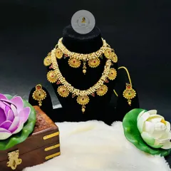 This beautiful coin necklace set, known as a putli haar, is a staple in Maharashtrian jewellery. The layered design with red stones and pearls gives it a rich, traditional feel.