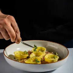 Good food matters, but how it's served is what guests notice first. A chef carefully adds a garnish with tweezers, showcasing our commitment to clean, sharp, and thoughtful presentation.