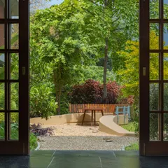 **Playfold Landscape, Ahmedabad:** We believe in blurring the lines between inside and out. This view from the home into the 'Playfold' courtyard shows how a once-underutilized lawn was transformed into a living landscape, seamlessly extending the home's daily rhythm into the outdoors.