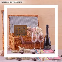 This is my classic wedding gift hamper, perfect for celebrating the happy couple. It features a wicker picnic basket containing a bottle of champagne, two elegant wine glasses, and other curated goodies for a romantic celebration.