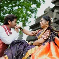 A classic romantic gesture. The groom-to-be kisses his navri's hand as she sits gracefully, dressed in a beautiful traditional saree.