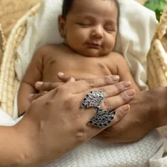Your hands protecting their tiny body. These detail shots, showing the scale of how small they are in your loving hands, are some of the most powerful images from a newborn session.