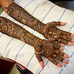 This design showcases a beautiful blend of different textures, from the fine-line jaal net on the fingers to the bold, shaded floral patterns on the arms.