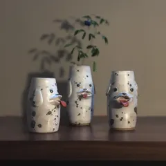 A trio of dog-faced vases, each with its own goofy expression. These are great for holding single stems or just for adding a bit of fun to your decor.