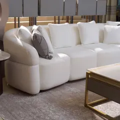 Meet the Aether Sofa, designed to be a journey in relaxation. Its gracefully curved silhouette and deep, generous cushions create a cocoon of pure comfort. We chose a high-quality ivory bouclé for its soft, looped texture, which adds a touch of cozy sophistication and serene, timeless charm to any living space.