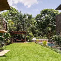 For this expansive villa at Embassy Boulevard, I designed a tropical paradise featuring a vast lawn, a serene poolside, and a custom gazebo, creating a seamless connection between the home and its natural surroundings.