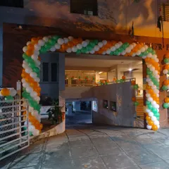 A large tricolor balloon arch at the entrance of a building complex.