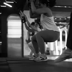 The TRX jump squat is an explosive movement that builds lower body power and cardiovascular endurance. Here you can see the focus and determination it takes to power through the set.
