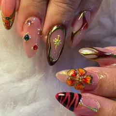 A full view of a truly eclectic and artistic nail set. Each nail tells its own story with a mix of 3D floral charms, tiger stripes, chrome accents, and carefully placed gems for a bold, high-fashion look.