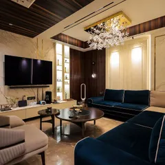 I love using color to set a mood. In this living room, the deep royal blue velvet sofa creates a focal point of luxury, beautifully balanced by the warm beige tones of the armchair and marble walls. The crystal chandelier adds a final touch of sparkle.