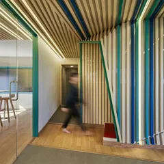 The colorful, banded walls in the Kadence Office create a strong visual identity and guide circulation through the space. This motion-blurred shot captures the energy and flow of the dynamic work environment we designed.