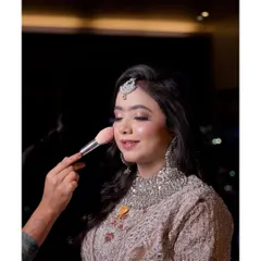 A behind-the-scenes moment, adding the final touch of blush. This is part of the process of creating that perfect, long-lasting glow.