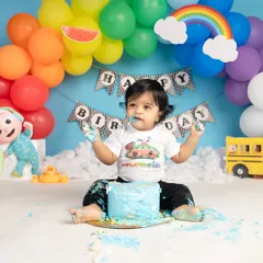 A colorful Cocomelon-themed cake smash is perfect for little fans of the show. This happy boy is having a wonderful time with his bright blue cake.