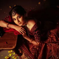 An artistic, top-down shot that creates a feeling of intimacy and contemplation. The warm light from the lantern, scattered petals, and the model's direct gaze make this a powerful and emotive branding portrait.