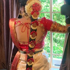 A South Indian bridal look is incomplete without the perfect hairstyle. This is a detailed view of a traditional Poola Jada, intricately woven with fresh flowers and classic hair jewels for a timeless and regal finish.