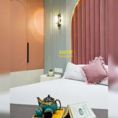 A close-up of the daughter's bedroom, showing the custom wardrobe with its curved door design and the elegant wall sconce. The combination of dusty rose, grey, and white creates a sophisticated yet youthful palette.