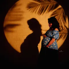 I use creative lighting and shadows to create artistic silhouettes that beautifully highlight the form and emotion of pregnancy. The palm leaf shadow adds a tropical, dreamy feel.