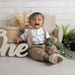 The purest joy! This little man's laughter is infectious as he celebrates his first birthday in a classic, rustic-themed studio setup.