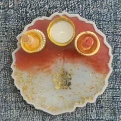 This is another one of my custom pooja thalis, designed to be a gorgeous addition to your festive decor. It features a Ganesha motif on a red and white resin base with sparkling gold flakes and dedicated holders for your pooja essentials.