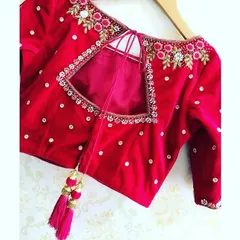 This red velvet blouse features a square keyhole back. The design is highlighted with floral embroidery and stonework, and finished with colorful tassels.