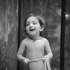 A joyful toddler in the middle of a water bath session, captured in beautiful monochrome. Black and white brings out the pure emotion in his expression.