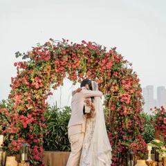The couple shares a hug under a magnificent bougainvillea arch, which served as the ceremony backdrop and a photo point.