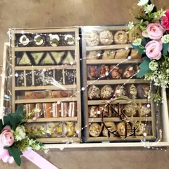 Our gourmet gifting services include beautifully arranged trays of traditional Indian sweets. This mithai hamper, presented in sectioned wooden boxes with a custom monogram, is a perfect example of our elegant food packaging solutions.