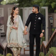 A beautiful shot of a couple walking hand-in-hand, dressed in elegant traditional attire for their Roka ceremony. This is a perfect example of a classic, graceful engagement portrait.