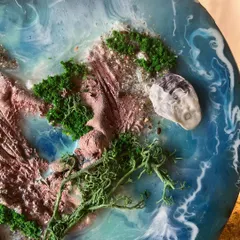 The details matter. I use natural elements like moss, sand, and tiny shells to create realistic and textured landscapes within my resin art.