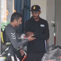 A candid moment between an instructor and a rider discussing track performance. These conversations are where real learning happens.