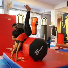 Our coach provides hands on support as a student practices a front walkover on a vaulting block. We prioritize safety and proper technique, ensuring every child masters skills at their own pace.