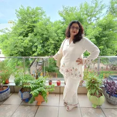 My client looks effortlessly chic in this white linen co-ord set. The top and sleeves are adorned with delicate, colorful floral hand embroidery, making it perfect for a smart casual look.