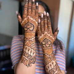 A beautiful back-of-hand design perfect for an engagement. The smiling client shows off the symmetrical patterns featuring hanging motifs and delicate florals.