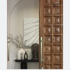 A detail shot of the entryway, where a console table sits beside the intricately carved door. Each piece feels deliberately chosen, contributing to the home's story of heritage and modernity.