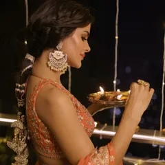 Glowing for Diwali. This look for Priyanka features a stunning orange lehenga, a traditional braided hairstyle, and warm, luminous makeup.