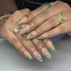 Pure glamour. These long, stiletto extensions have a nude base and are covered in gold foil and large, multi-faceted crystals for a dazzling effect.
