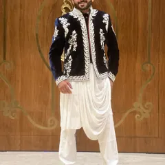 A classic look for a Sufi night. This royal blue velvet jacket with intricate white embroidery, paired with a draped kurta, is all about sophisticated style.