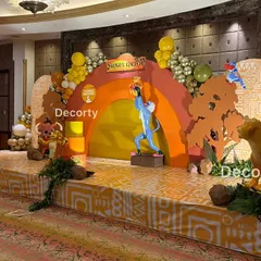 The main stage setup for the Lion King party, featuring the iconic Pride Rock scene with Rafiki presenting baby Simba. Life-sized characters and themed patterns complete the immersive experience.