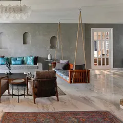 For this Delhi residence, we introduced a traditional wooden swing into a contemporary living space defined by cool grey lime-plastered walls and polished marble floors. This adaptive reuse project focuses on creating a harmonious balance, where modern minimalism is softened by familiar, tactile elements that evoke a sense of calm and playfulness.