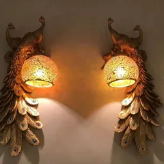 Inspired by India's national bird, these peacock wall lights bring a touch of regal artistry to your home. The detailed golden feathers and cracked glass globe create a warm, inviting glow that is both dramatic and elegant.