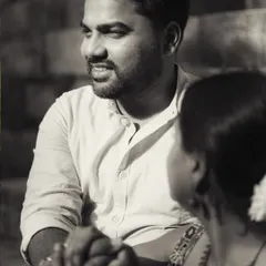 A black and white candid shot focusing on the groom's loving gaze. It’s a quiet, observant moment that speaks volumes about his feelings.