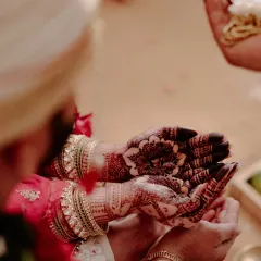 A candid moment during a wedding ceremony, highlighting the dark and intricate henna stain on the bride's palms. My natural henna ensures a color that stands out in every ritual.