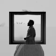 An artistic silhouette of the groom, framed within a window, showcasing our creative approach to groom portraiture.