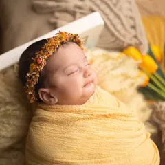 A sweet, contented smile from this little one wrapped in sunny yellow. You can just feel the happy dreams she is having.